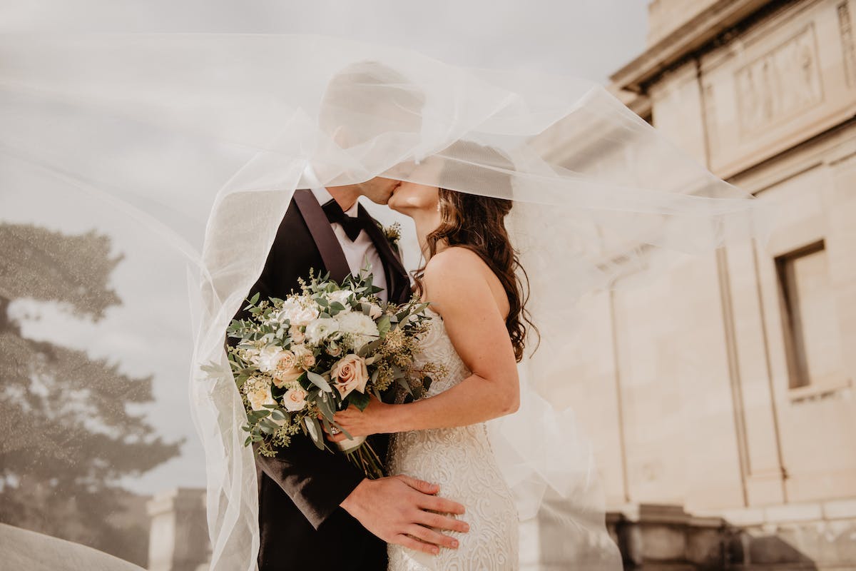 Nunta primăvara - de ce să-ți organizezi nunta primăvara- miri care se saruta, buchet de flori-min